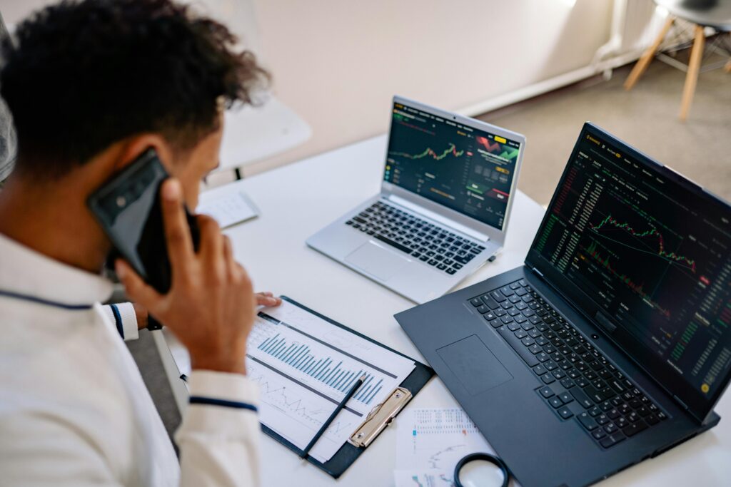 pexels-photo-7691740-7691740 Man analyzing stock market charts on laptops while talking on a cellphone.